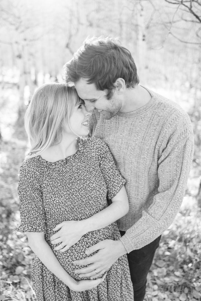 Maternity photo with couple smiling at each other. Timeless black and white image by Alisa Dalton Photography. 