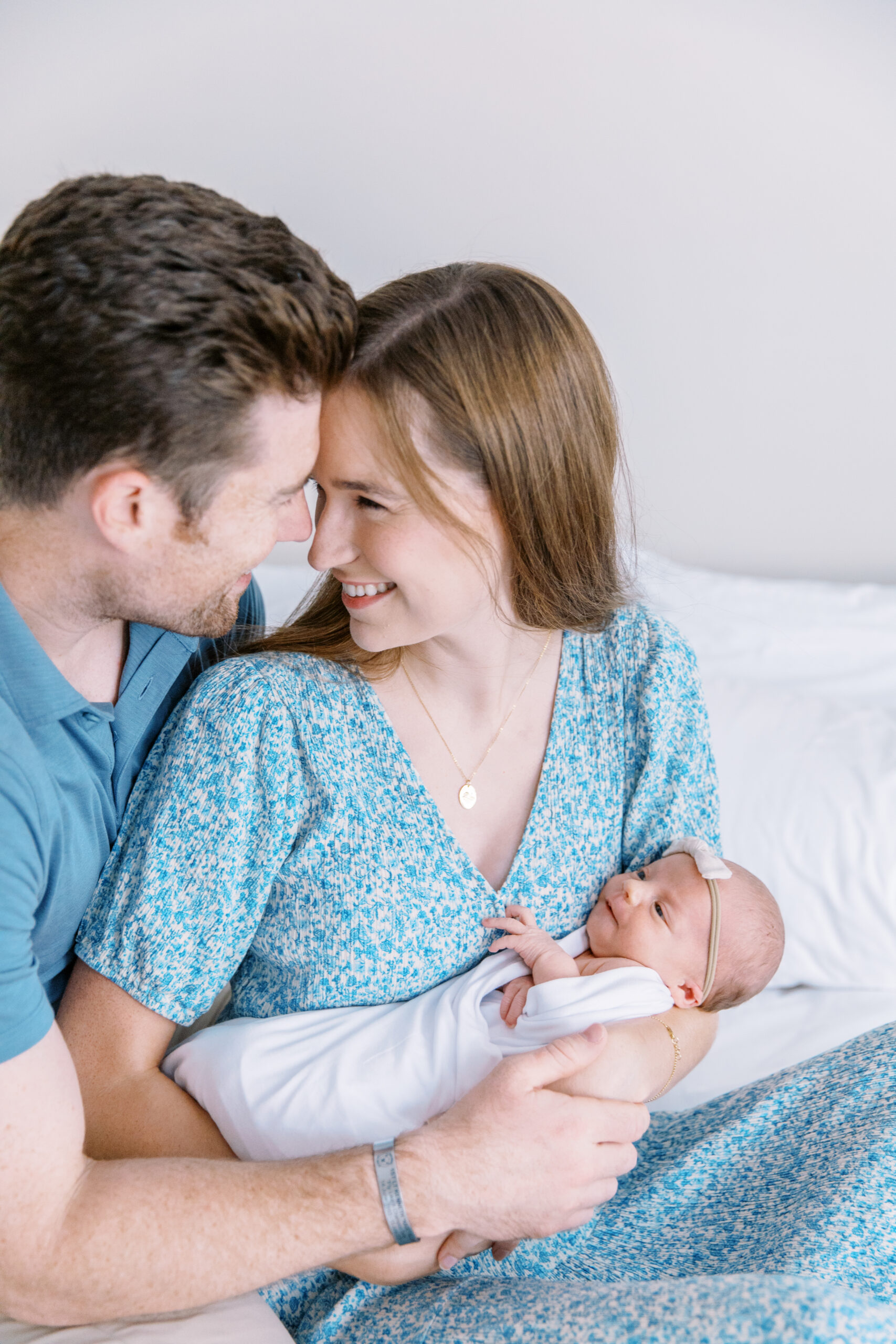 Couple looking at each other lovingly while holding newborn baby