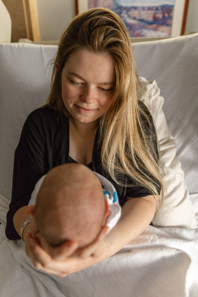 First time mom looking lovingly at baby in hospital